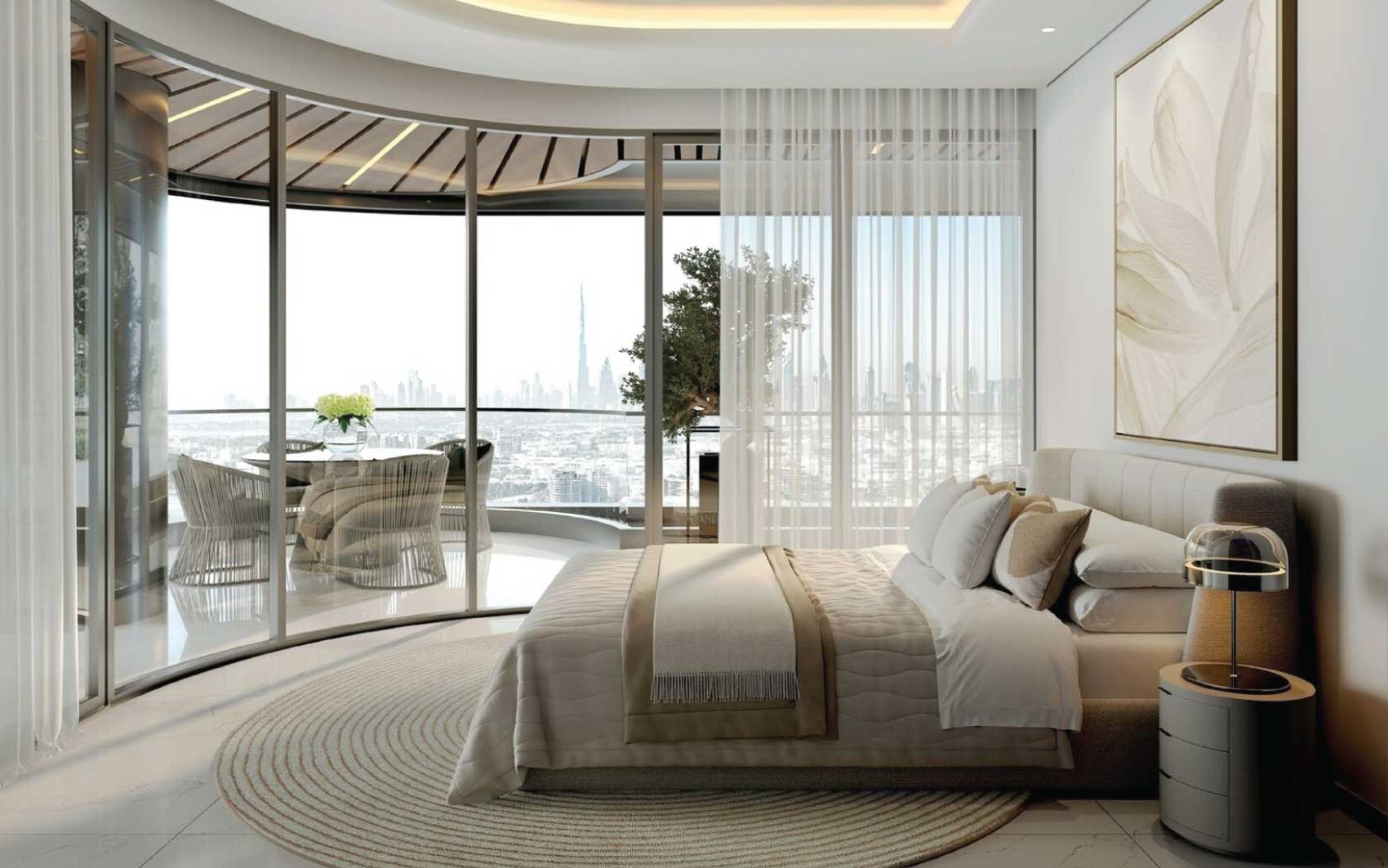 Elegant bedroom with curved glass wall, balcony seating, and panoramic Dubai skyline view