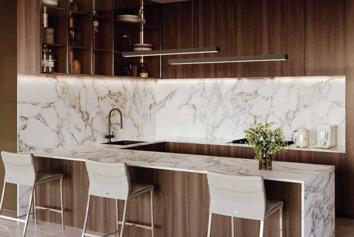 Contemporary kitchen design with white marble countertops, wood cabinetry, and breakfast bar
