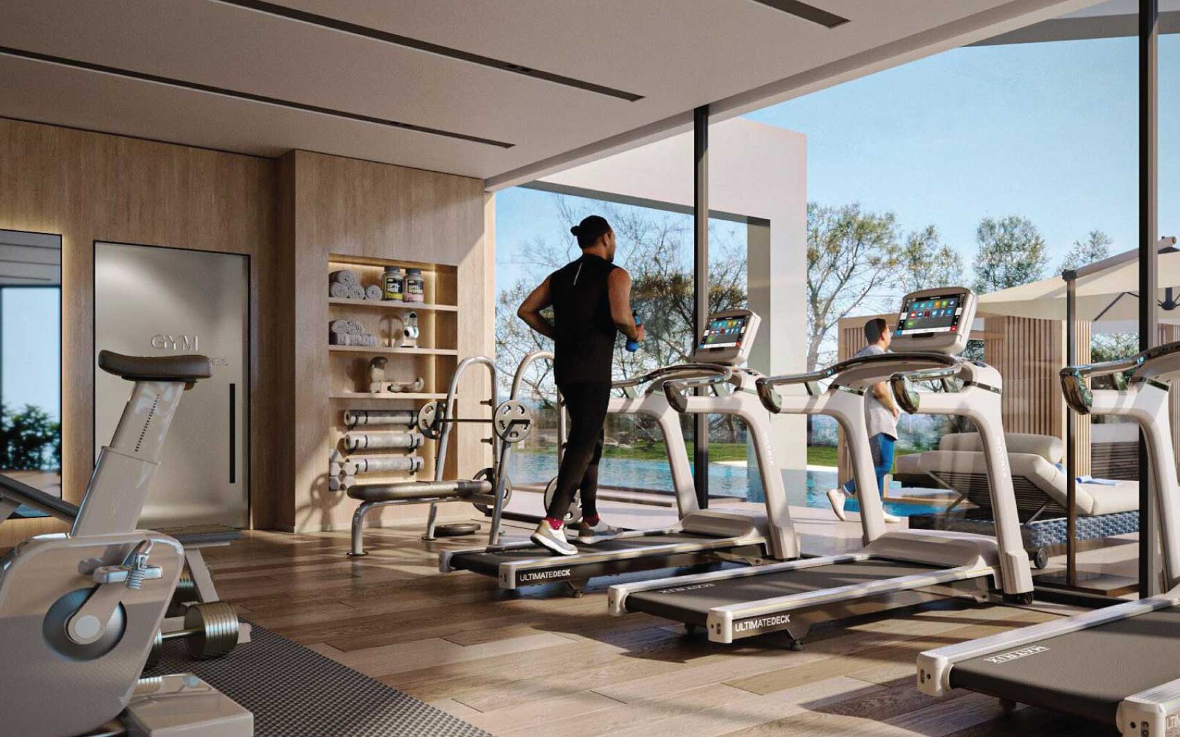Modern gym with treadmills facing outdoor pool and scenic views