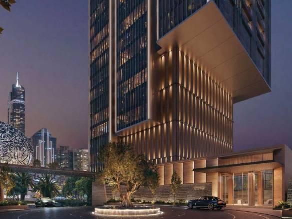 Night view of illuminated skyscraper entrance with luxury car and city skyline backdrop