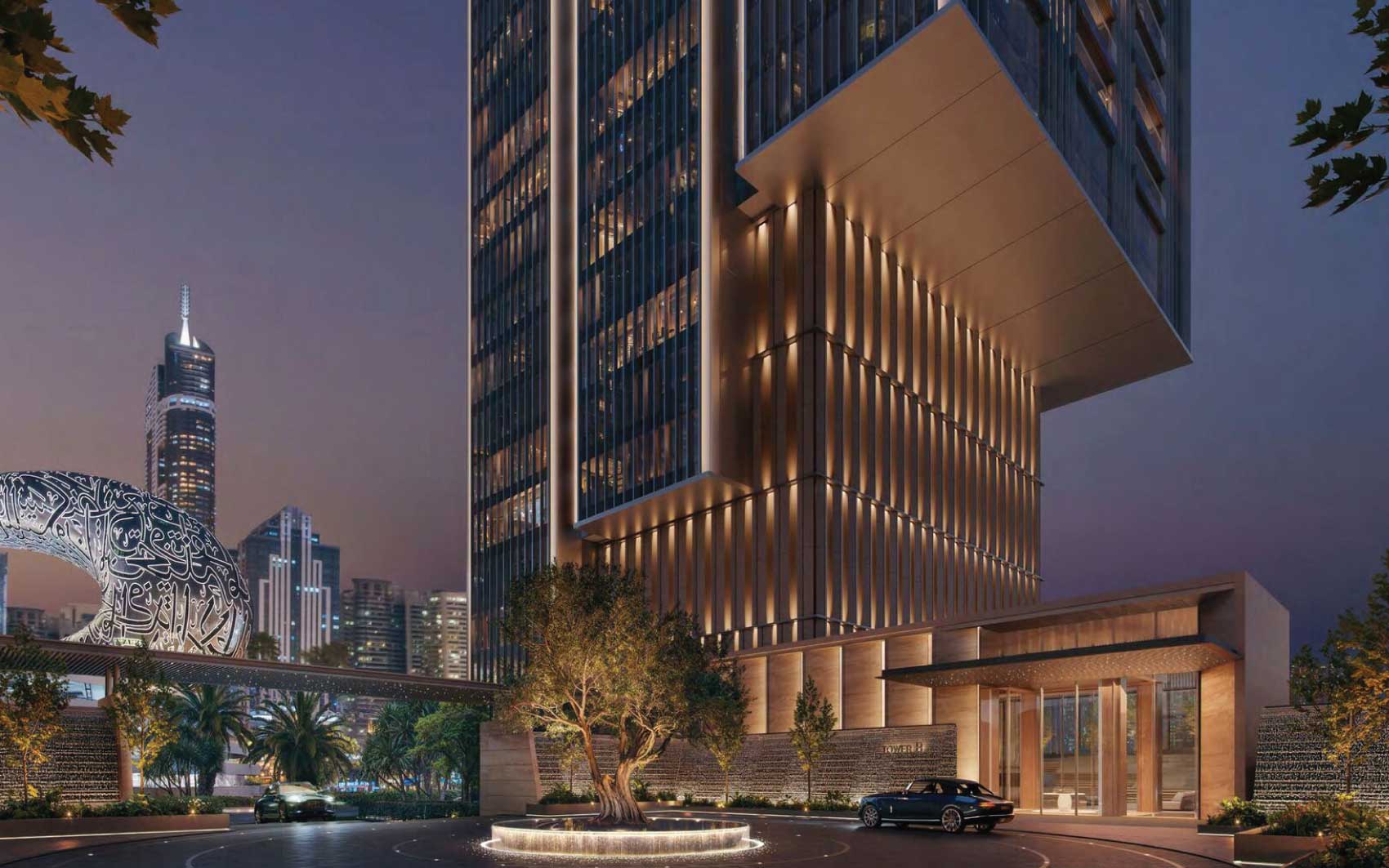 Night view of illuminated skyscraper entrance with luxury car and city skyline backdrop
