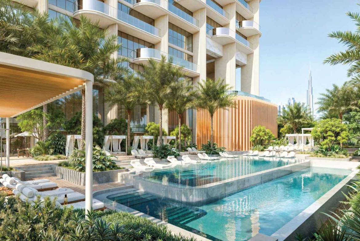 Resort-style outdoor pool with sun loungers, cabanas, and lush landscaping at modern residential complex