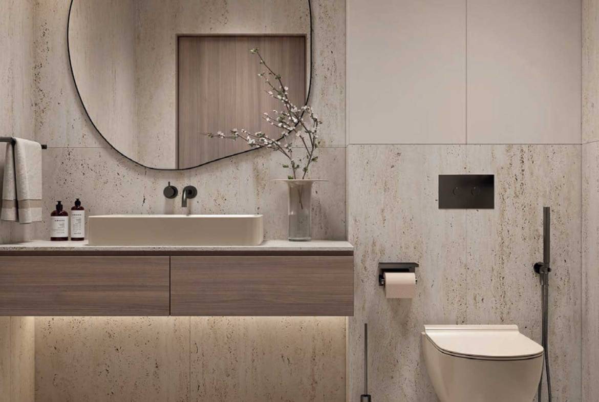 Modern bathroom with floating vanity, round mirror, and stone walls