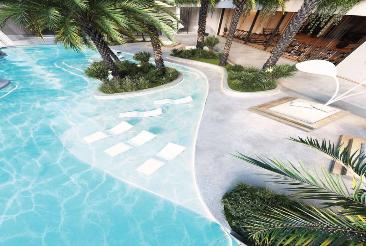 Luxury resort-style pool with palm trees and sun loungers in shallow water