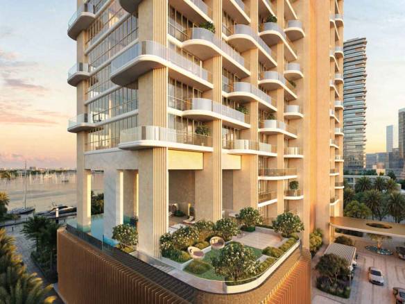 Modern high-rise residential tower with spacious balconies overlooking the marina at sunset
