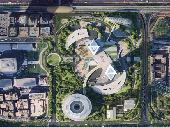 Aerial view of futuristic architectural complex surrounded by landscaped greenery
