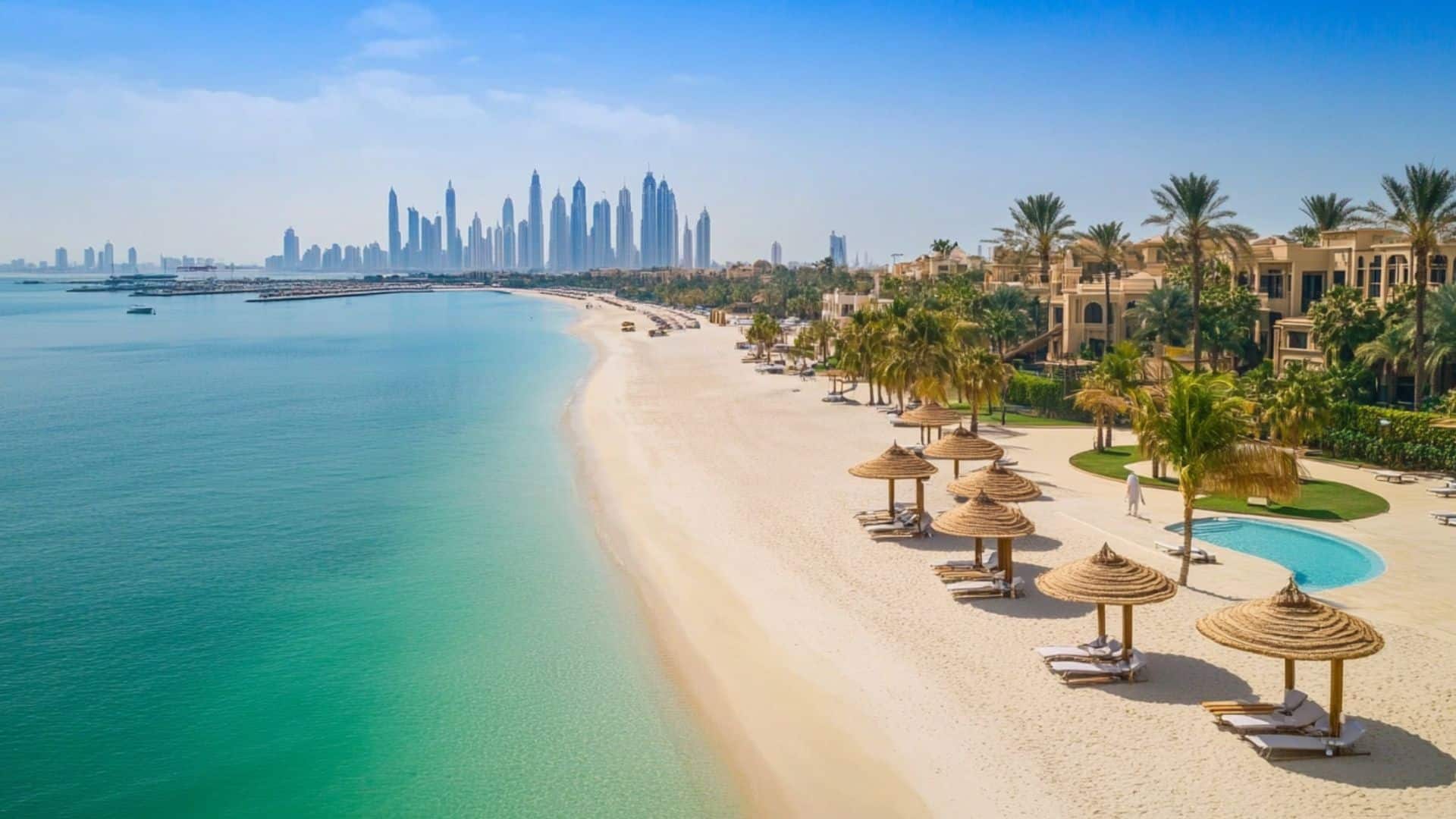 Exclusive Dubai beach with luxury villas, shaded loungers, palm trees, and crystal-clear water overlooking the city skyline
