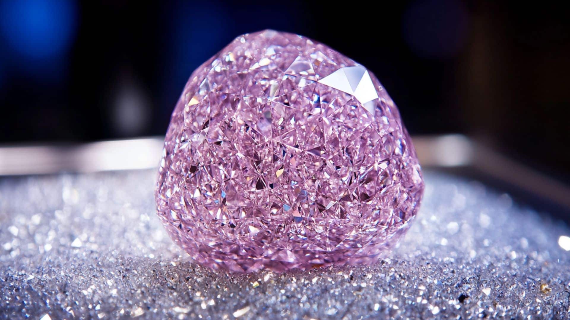 Brilliant pink diamond on glittering surface under studio lights